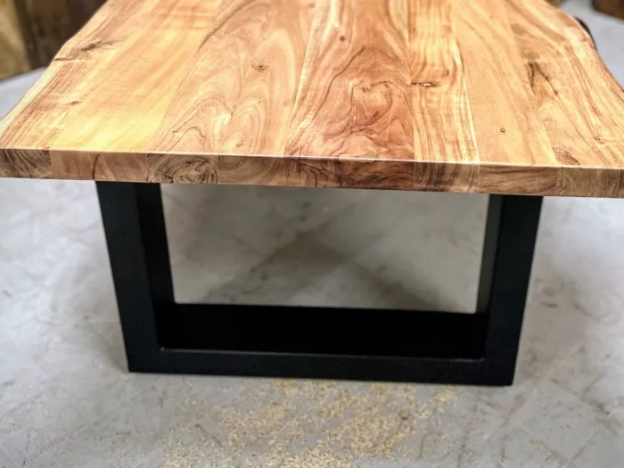 Une table basse avec des pieds en acier en forme de U