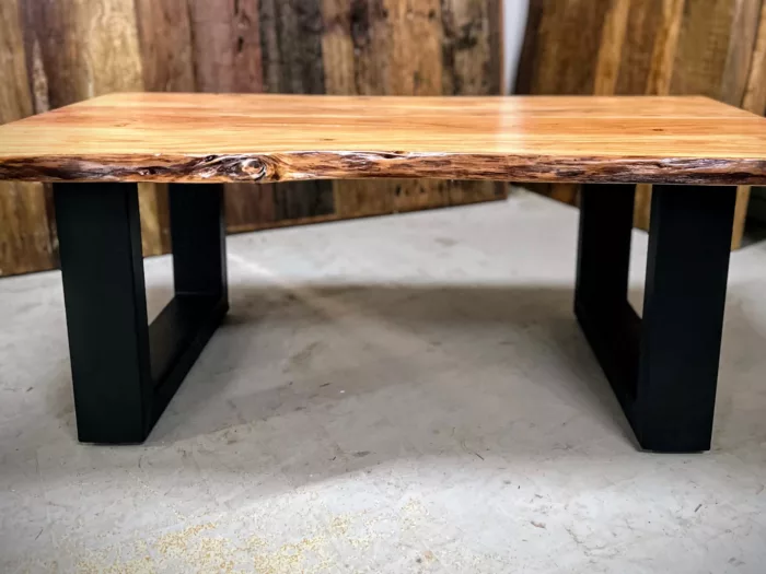 Une table basse en bois massif avec des pieds en acier en forme de U