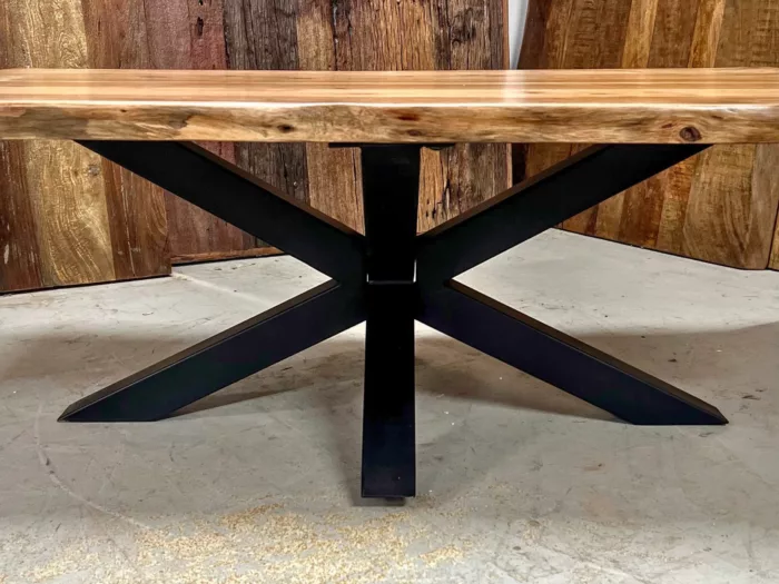 Une table basse avec un pied en acier en forme d'étoile