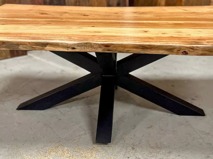 Une table basse avec un pied central étoile