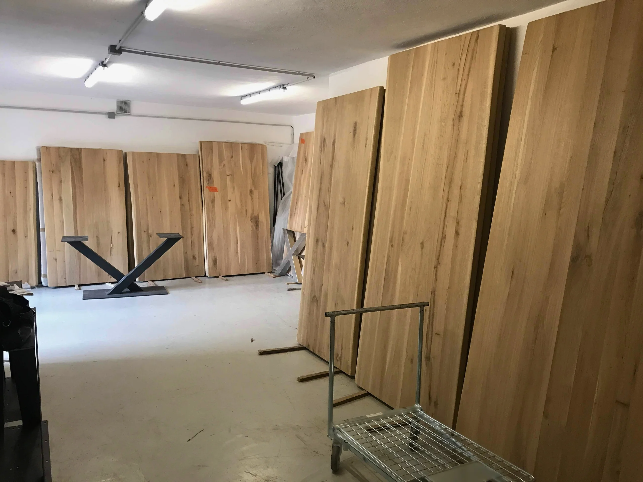 Un atelier avec des plateaux de table rectangulaires en chêne massif posés contres les murs