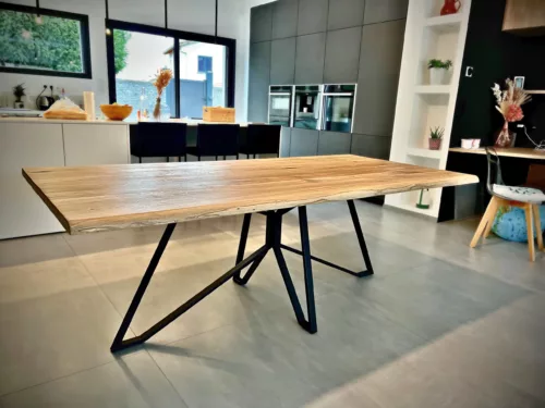 Une table en bois avec un pied de table central en acier Spider