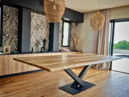 Une table plateau bois et pied central en acier noir