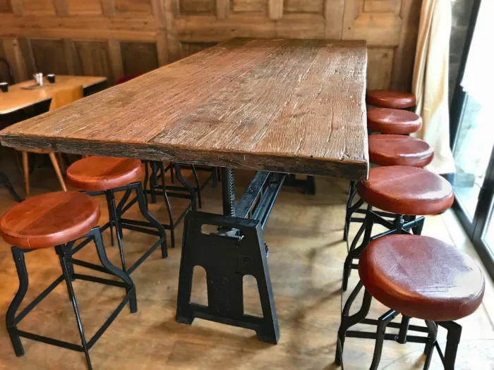 Une table réglable Café de Lyon avec des tabourets