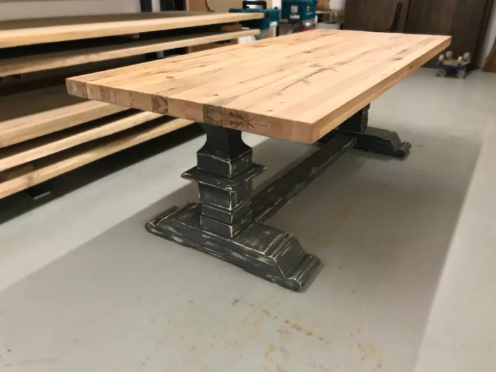 Un atelier avec des plateaux de table, et une table monastère en bois