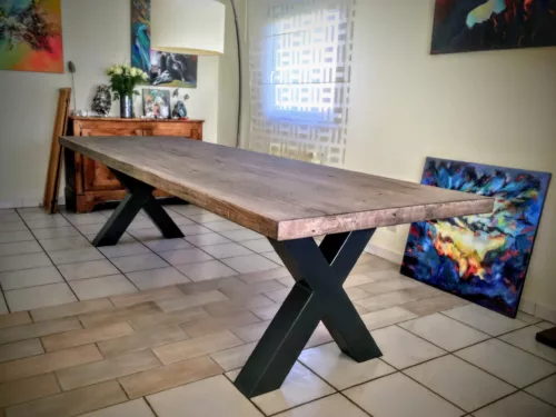 Une table de salle à manger avec un pied de table Croix en acier