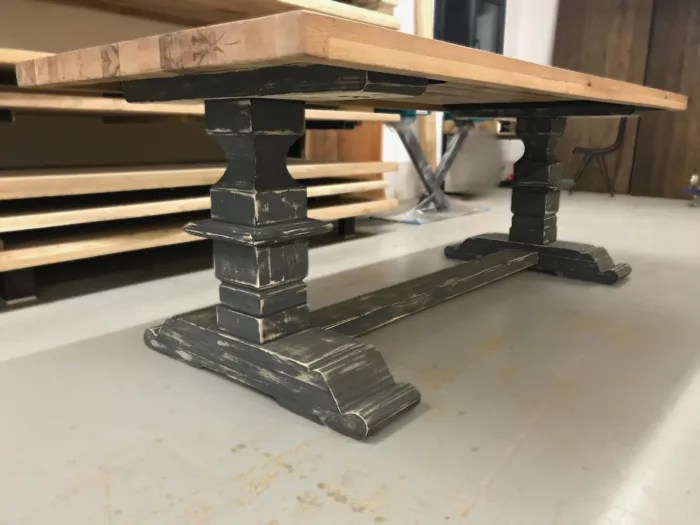 Un atelier avec des plateaux de table, et une table dotée d'un pied de table monastère en bois