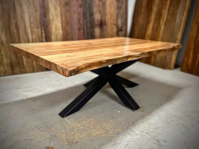 Une table basse avec un pied étoile dans un atelier de menuiserie