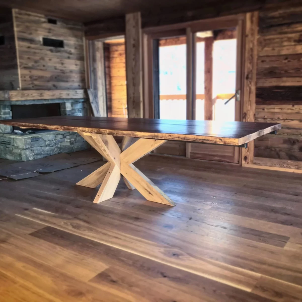 Une table en bois avec un pied central dans un chalet