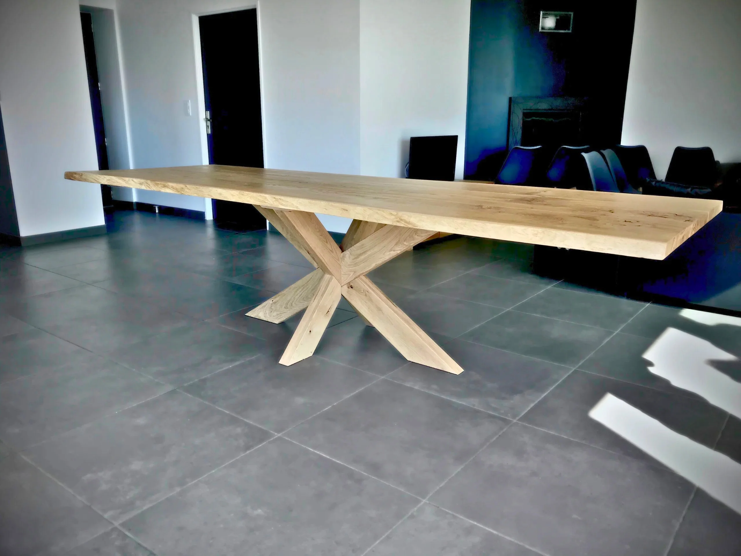 Une table avec un pied central en bois massif dans un salon